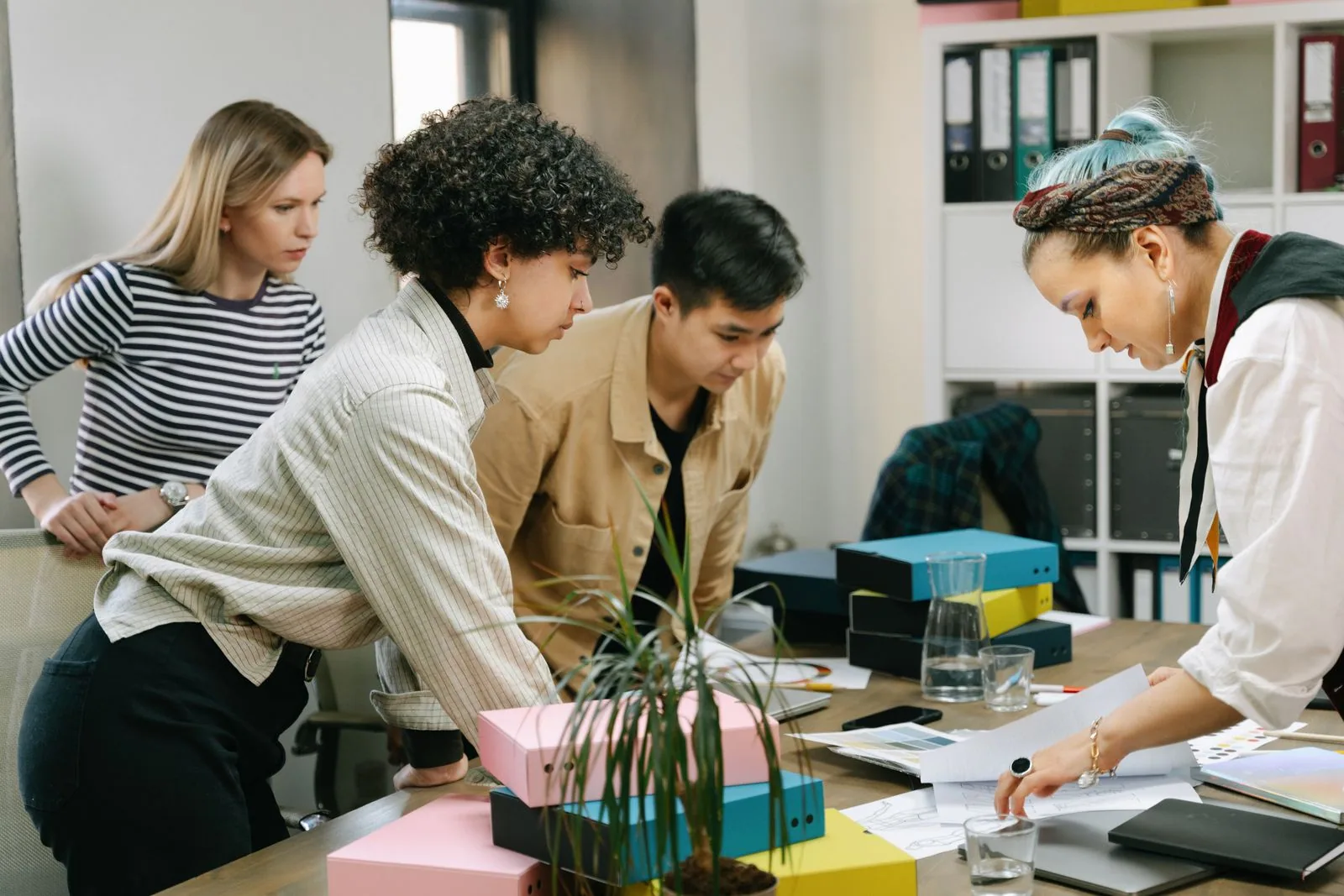 A small team working through paperwork around a table
