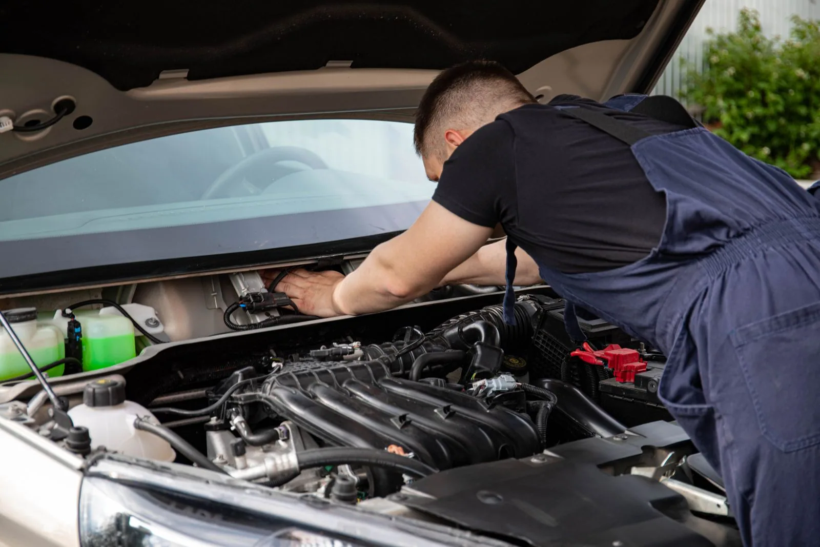 A mechanic working under the bonnet of a car
