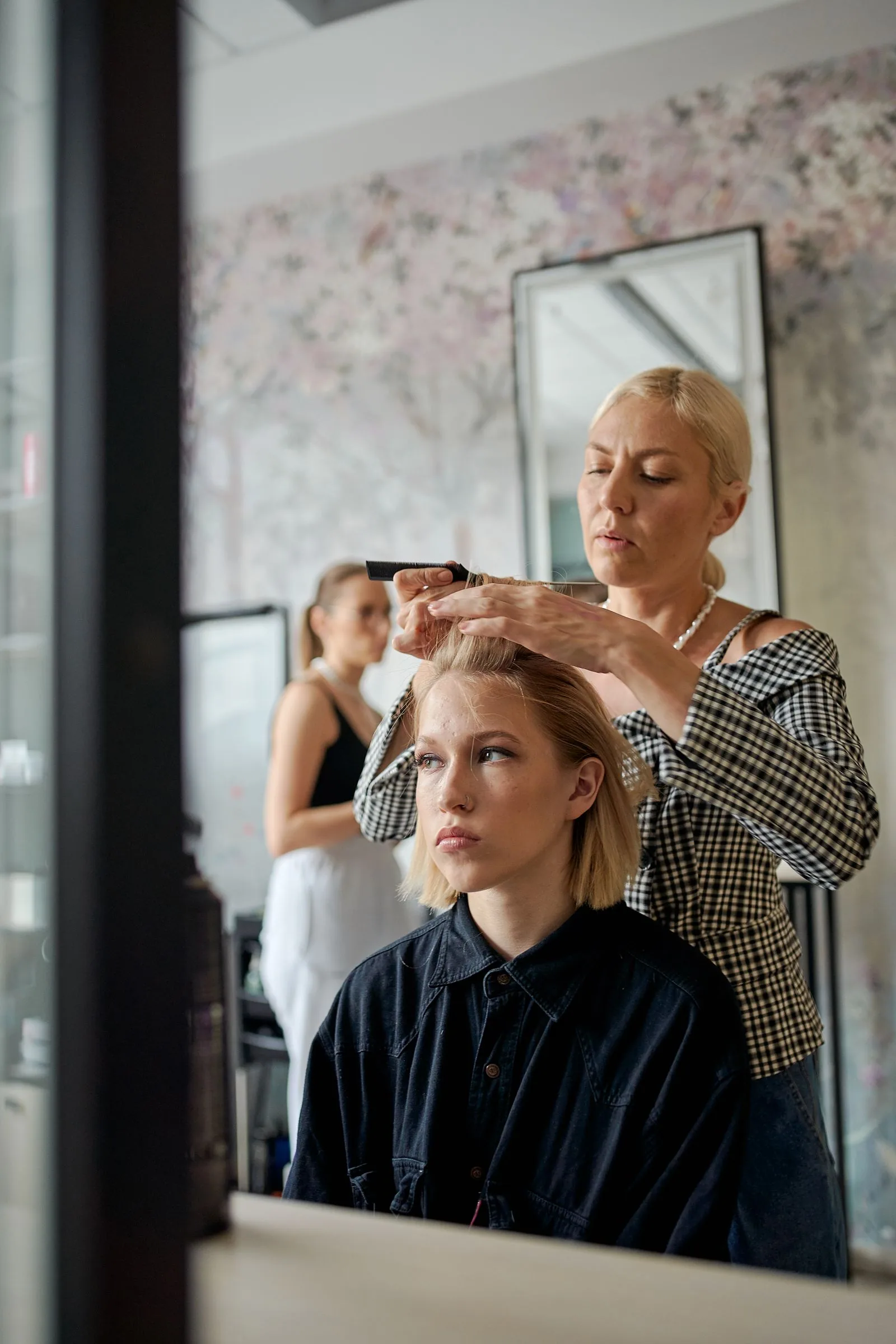 A stylist finishing a client's hair in a salon