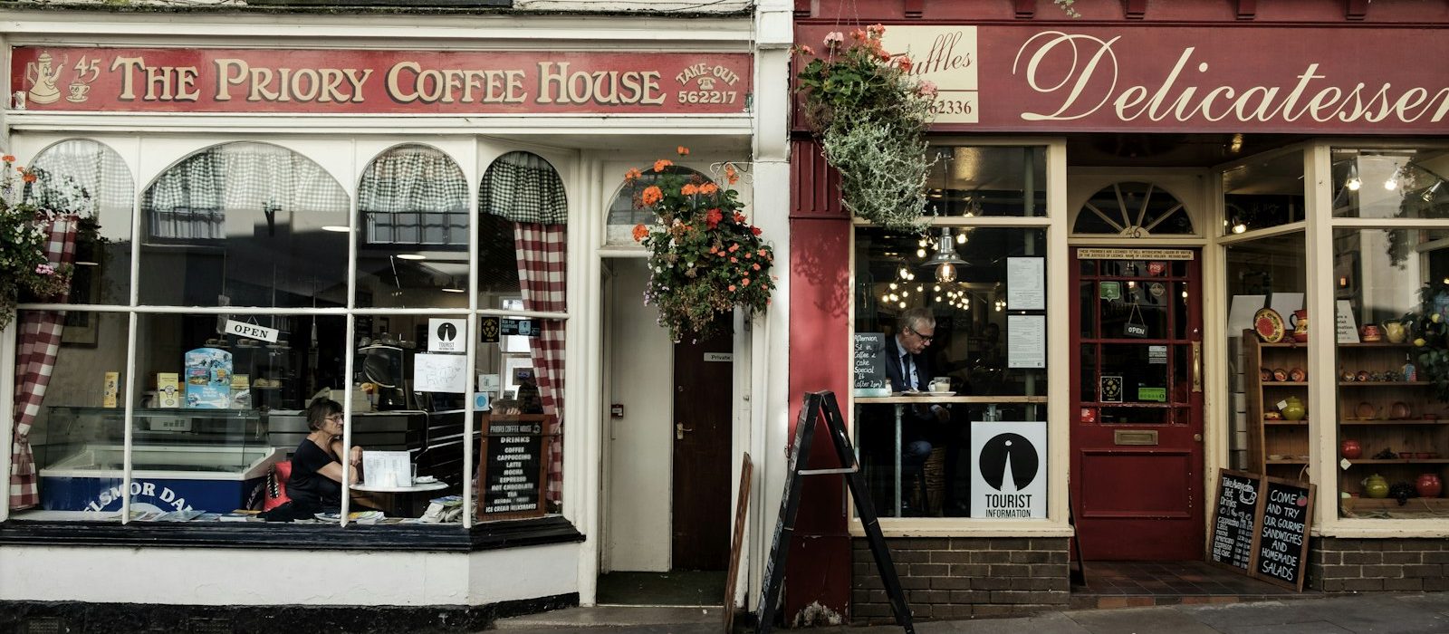 A coffee house and a delicatessen side by side on a high street