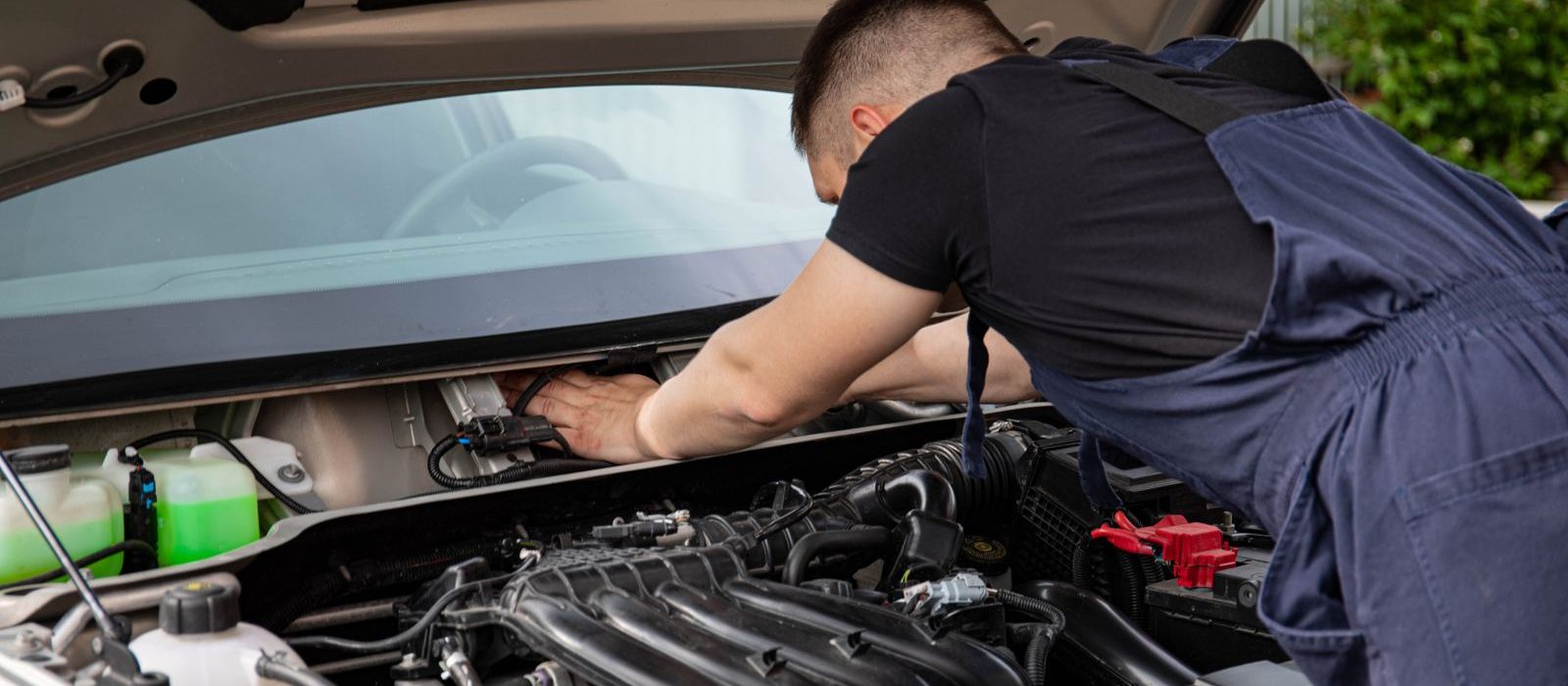 A mechanic working under the bonnet of a car